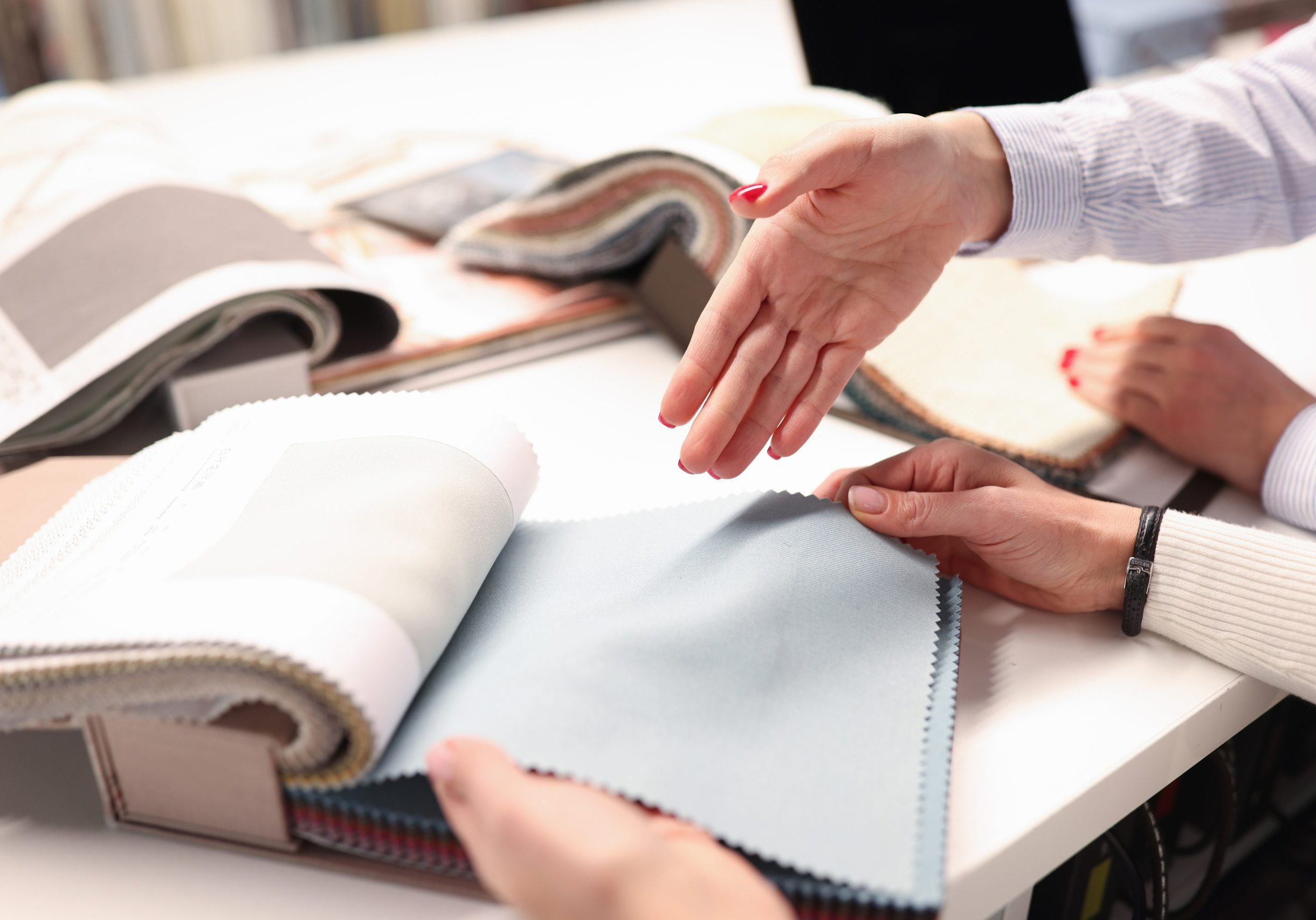 Women holding catalog and choosing fabrics closeup. Designer tips concept